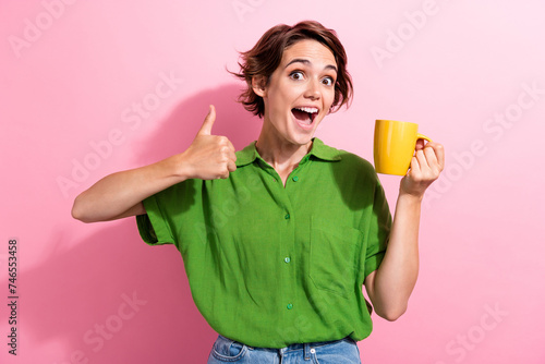 Fotografia Photo portrait of attractive young woman hold coffee mug show thumb up dressed s