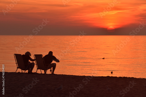couple watches the sunset over the sea