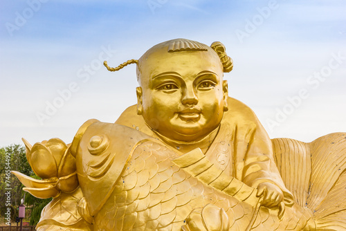 Golden statue of a man with fish in Yangliuqing town in Tianjin, China photo