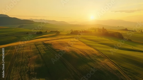 Sunrise over rolling green hills and agricultural fields. Serenity and nature concept. Design for environmental campaign, travel brochure, and landscape photography