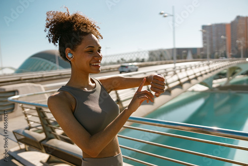 Young fit woman looking at smartwatch and counting calories burned. Healthy life concept photo