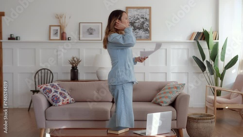 young woman walks around the room and rehearses the character lines holding script in hands. makes mistake and gets angry and irritated