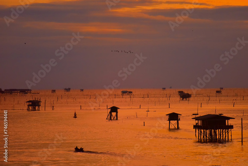 Silhouette  Long shot of Oyster farm in the open sea at the amazing sunset.