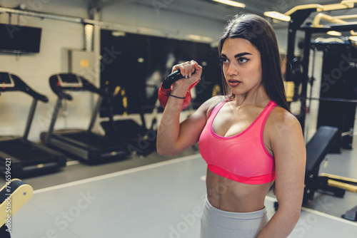 Fitness  exercise and woman with dumbbell in the gym doing workout  training and weight lifting. Health  wellness and happy female exercising with equipment in sports center with smile on face.