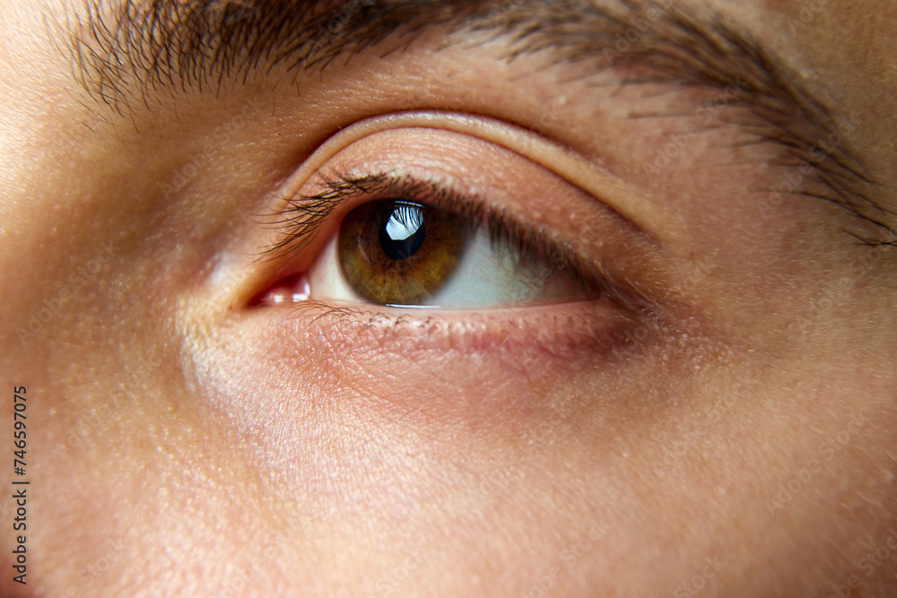 Fototapeta premium Close up photo of brown eyes of young man. Male model with well-kept skin without imperfections. Concept of beauty treatment, male health, body care, spa treatment, hygiene.