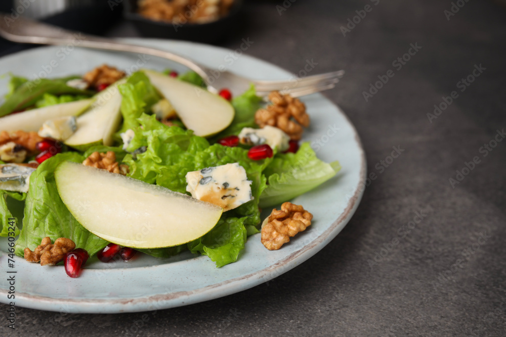 Delicious pear salad on dark textured table, closeup