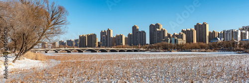 The frozen river surface and urban skyline in urban parks after snow #746610421