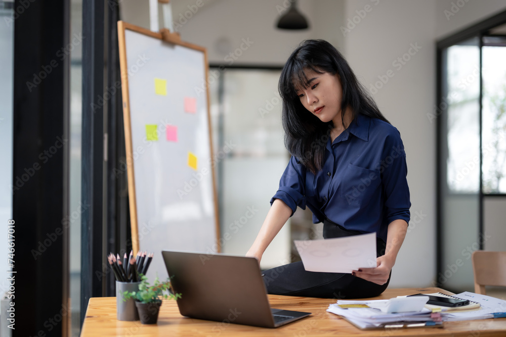 Young businesswoman checking documents in work area. Young businesswoman checking documents in work area.