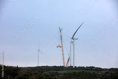 Foto Wind turbine being repaired, assisted by crane and elevator