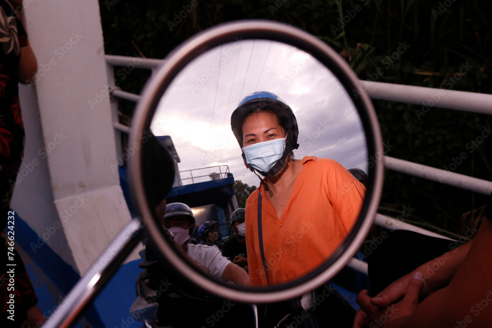 Reflection of woman with mask in a motorbike mirror. Reflection of woman with mask in a motorbike mirror.