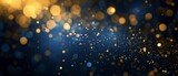 Blue and Gold Abstract Background with Shimmering Particles, Festive Christmas Bokeh Lights. Elegant Dark Blue Texture with Gold Foil Shine for Holiday Design Projects