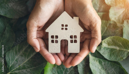 hands cradling paper house symbolizing shelter, family, homelessness, and home innovation