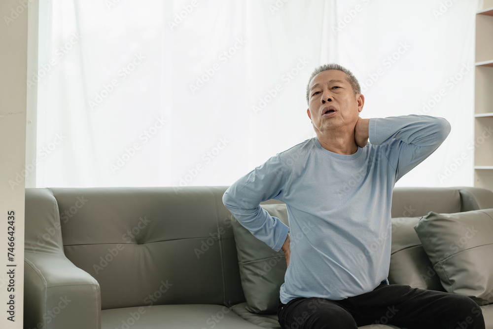 Asian elderly man has back pain and sickness in bed at home, unhappy elderly man touching his back seriously and trying, elderly care concept Asian elderly man has back pain and sickness in bed at home, unhappy elderly man touching his back seriously and trying, elderly care concept