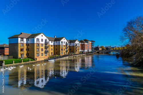 A view along the north shore of the River Nene in the centre of Peterborough, UK on a bright sunny day photo