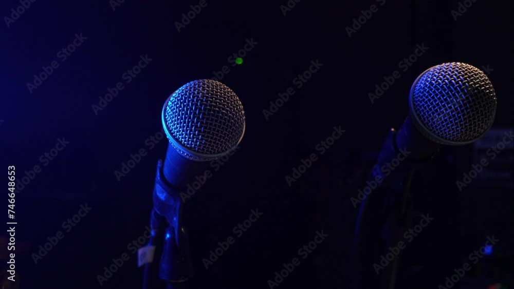 Two Studio Condenser Microphone Isolated in Black, Studio Microphone in Empty Recording Studio with Copy Space, in Neon Blue Light. Two Studio Condenser Microphone Isolated in Black, Studio Microphone in Empty Recording Studio with Copy Space, in Neon Blue Light.