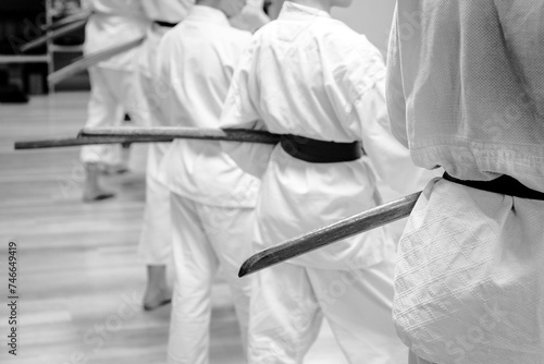 Black and white martial arts background. Silhouettes of people practicing bokken with a wooden sword.