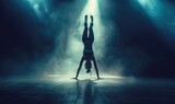 Female gymnast on dark background of studio with backlight. Acrobatic girl performing handstand.