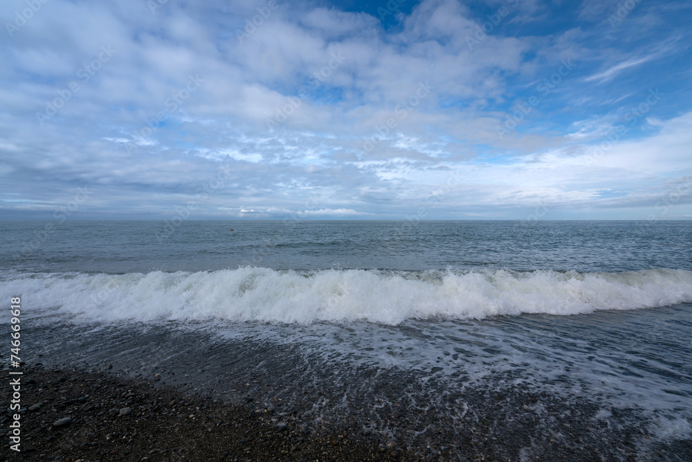 Black Sea on the Sochi coast and a pebble beach on a sunny day with clouds, Sochi, Krasnodar Territory, Russia Black Sea on the Sochi coast and a pebble beach on a sunny day with clouds, Sochi, Krasnodar Territory, Russia