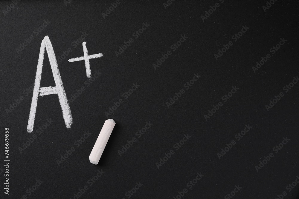 School grade. Letter A with plus symbol and chalk on blackboard, top ...