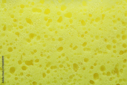 New yellow sponge as background, closeup view