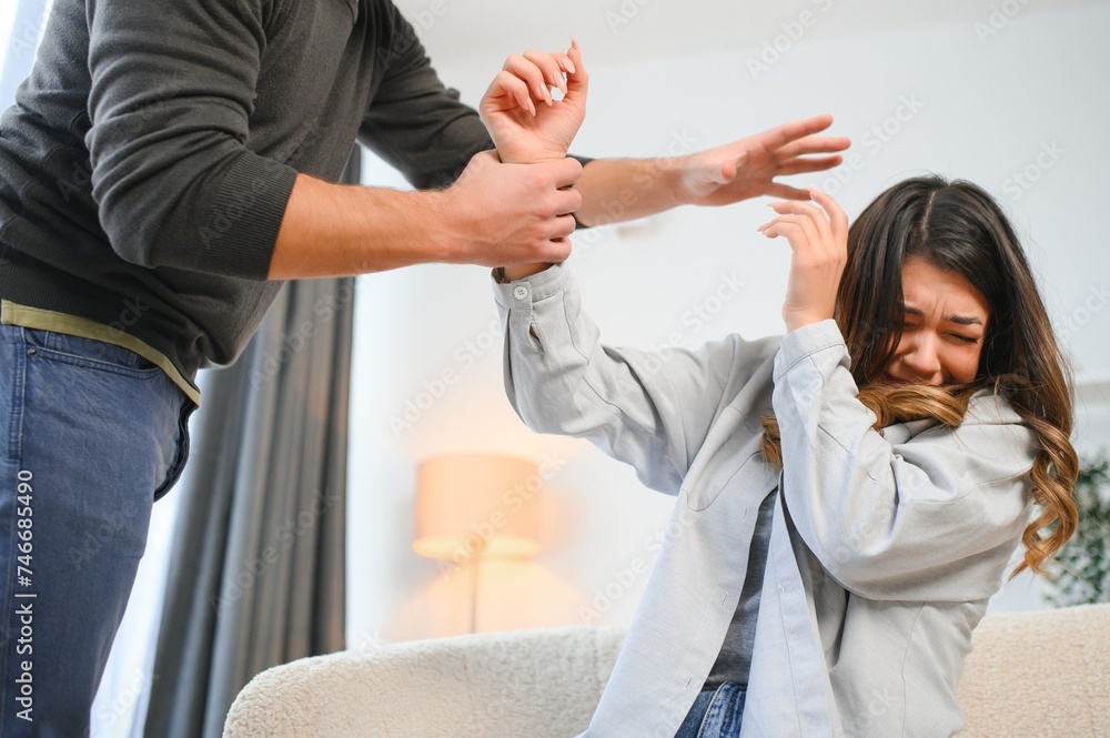 Fototapeta premium Angry husband beats his wife, domestic violence