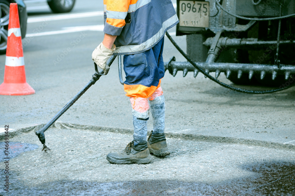 worker spraying bitumen repairing the road, oil tar spreader truck worker spraying bitumen repairing the road, oil tar spreader truck