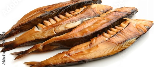 A pile of dried fish is neatly arranged on top of a white table, showcasing their texture and color. The dried fish appear to be ready for consumption or further seasoning. photo