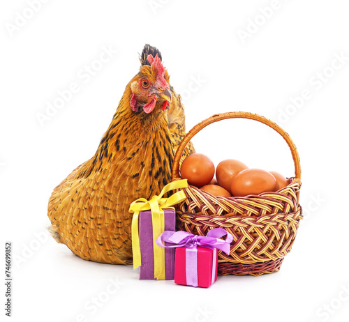 Chicken near a basket with eggs and gifts.