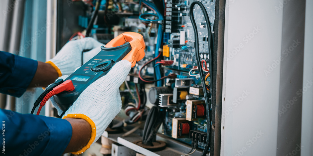 Technician is checking air conditioner refrigerant system maintenance and check switch board control Technician is checking air conditioner refrigerant system maintenance and check switch board control