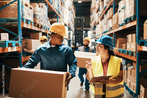 Workers in safety gear checking inventory in warehouse
