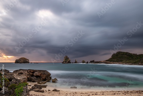 Stony coast with sharp rock formations on a bay in the sea. rainy sunrise, dramatic mood. Pointe des Chateau overlooking Pointes des colibris on Grande Terre, Guadeloupe, French Antilles, Caribbean © Jan