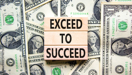 Exceed to succeed symbol. Concept words Exceed to succeed on beautiful wooden blocks. Dollar bills. Beautiful dollar bills background. Business and exceed to succeed concept. Copy space. photo
