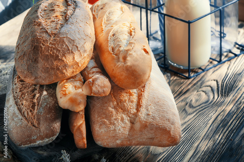 Assortment of various delicious freshly baked breads on a white wooden background. Ciabatta, grissini, pastries, baguette of various varieties. Homemade healthy bread, close-up