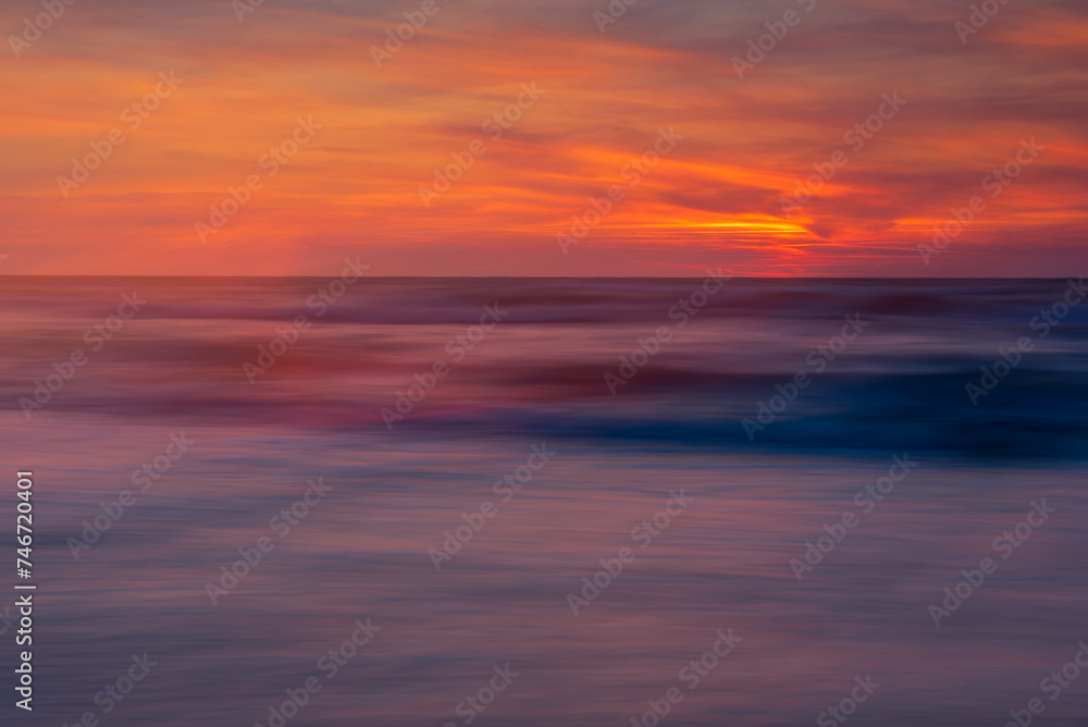 blurred sea, illuminated with the colors of the setting sun - obrazy, fototapety, plakaty 