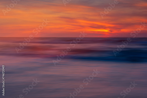 blurred sea, illuminated with the colors of the setting sun
