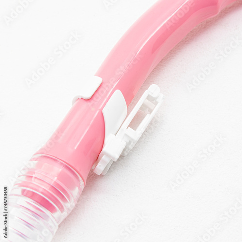 Pink snorkel for snorkeling and diving on white background. Plastic attachment to the mask closeup