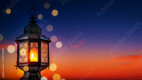 Decorative Arabic lantern with a glowing burning candle, in the evening against the background of the evening sky at sunset, copy space. Muslim Holy Month Ramadan Kareem background