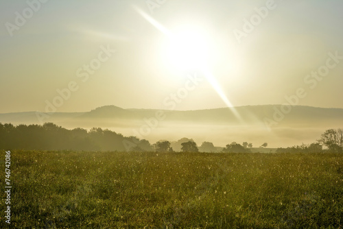 Early morning landscape with fog and sun