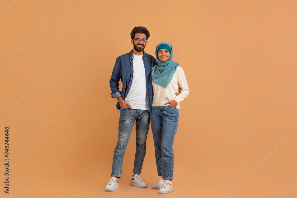 Portrait Of Happy Modern Muslim Couple Standing On Beige Studio Background Portrait Of Happy Modern Muslim Couple Standing On Beige Studio Background
