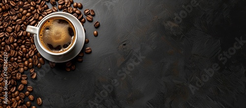 A top-down view of a ceramic cup filled with hot coffee, placed on a surface covered with roasted coffee beans. The beans are various shades of brown, creating a visually appealing contrast with the photo