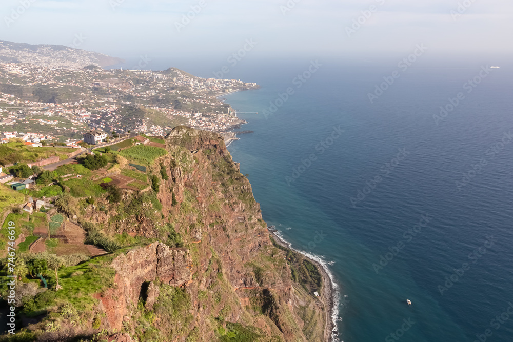 Spectacular aerial view of city Funchal seen from viewing platform Cabo Girao Skywalk, Madeira island, Portugal, Europe. Majestic coastline with steep cliffs along Atlantic Ocean. Travel destination