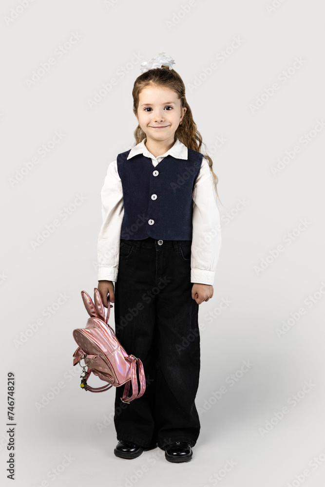 Little girl with electric blue blazer holding pink backpack