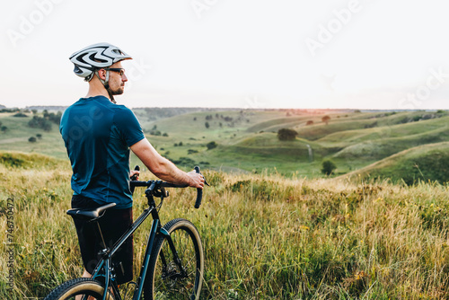 Fototapeta Naklejka Na Ścianę i Meble -  Male caucasian cyclist standing with his bike. Young pretty athletic man with bicycle outdoor. Active sporty people concept image