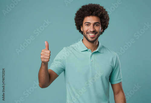A man with afro hair in a teal polo shirt, smiling and gesturing thumbs up. Represents positivity and approachability.