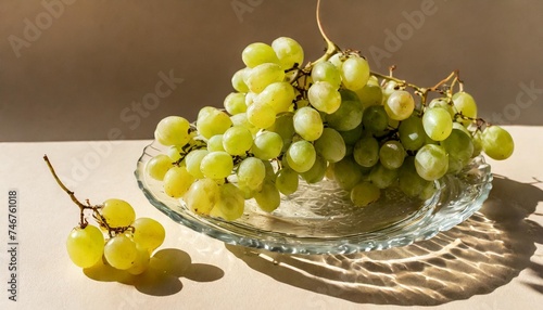 natural white grapes on glass transparent plate with shadows at sunlight minimal style summer fruit still life photo green berries of grape on beige background healthy vegan sweet food