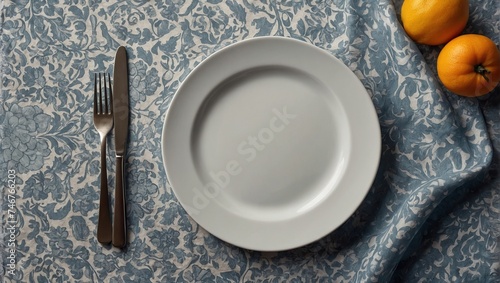 Top view on colored background empty round white plate on tablecloth for food