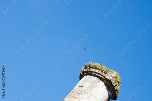 Altilia: In the foreground a column with a Roman capital stands out against the blue sky while a small red plane passes in the background - Molise, Italy photo