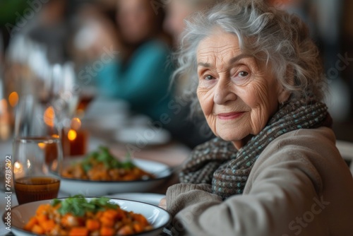 An elderly woman is seated at a table  savoring a plate of nutritious food.