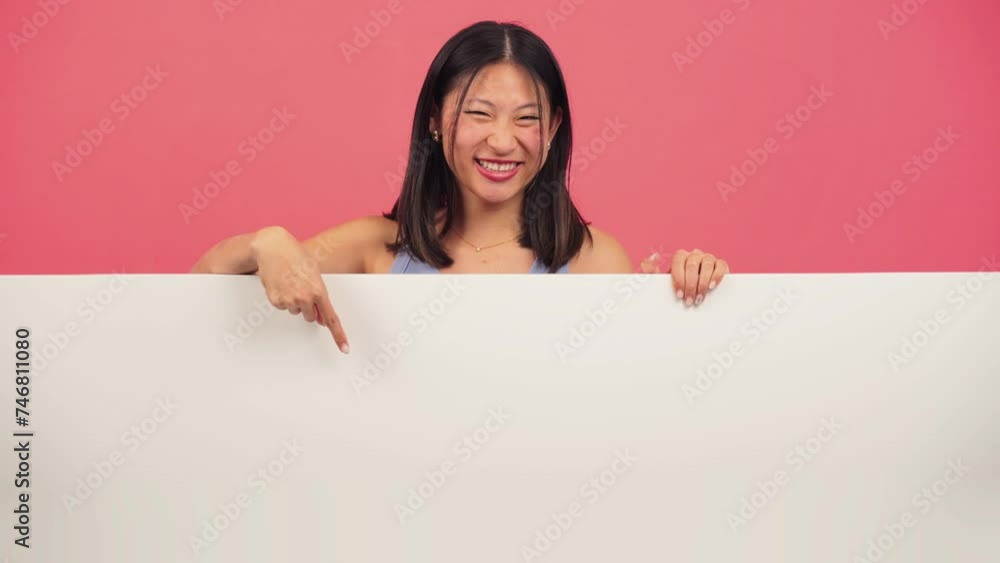 Young asian woman pointing a blank empty board against red backdrop. Advice copy space mockup. Chinese teenage girl showing a down billboard copyspace at pink color background wall. Female presenting Young asian woman pointing a blank empty board against red backdrop. Advice copy space mockup. Chinese teenage girl showing a down billboard copyspace at pink color background wall. Female presenting