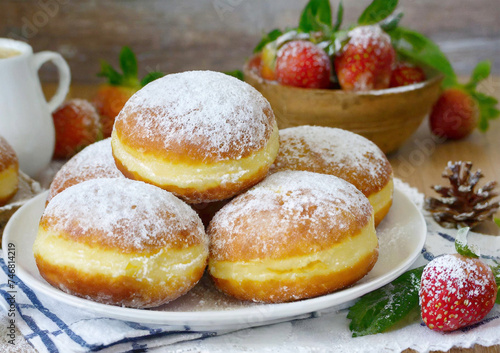 Powdered creme doughnuts on a plate.
